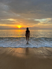 Thailand, sunset on the sea with a girl's figure, rear view.