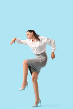 Businesswoman in pose of marionette on blue background