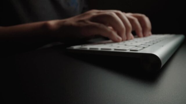 Close-up man typing on computer keyboard with hands and fingers. Macro soft focus dolly shot. Computer programming, text chat online messaging and online marketing business concept. Glean