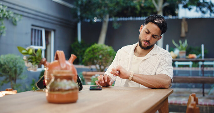 Watch, late and man waiting for date on valentines day, anniversary or romantic celebration. Worry, reservation and male person with time management for dinner at outdoor restaurant or diner.