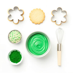 Baking ingredients and tools arranged for decorating cookies with vibrant green frosting