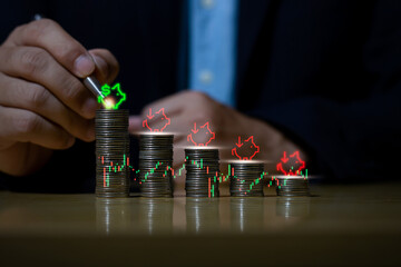 Businessman putting down money, pointing with pen and showing candlestick symbol for investing, finance, saving money, interest rate or dividend investment, business growth concept.