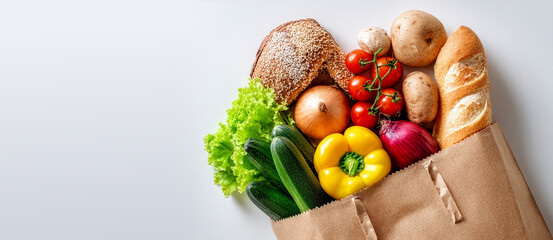 A eco-friendly brown paper bag filled with fresh vegetables, fruits and bread on white background