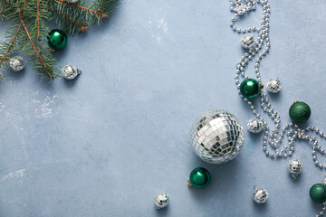 Naklejka premium Frame made of disco balls, fir tree branch and Christmas decor on blue grunge background