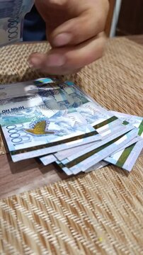 Examining kazakh tenge currency notes with intricate designs and features