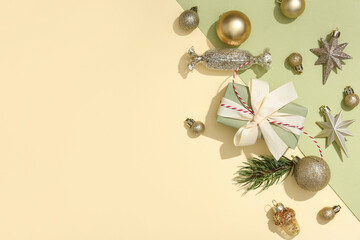 Composition with golden Christmas balls, gift box and fir tree branch on color background