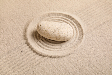 Composition with spa stone and lines on sand as background, closeup. Zen concept