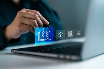 Business person accessing digital book icon on laptop screen, representing online library, e-learning, cloud-based education, digital archive management and knowledge access in modern workplace.