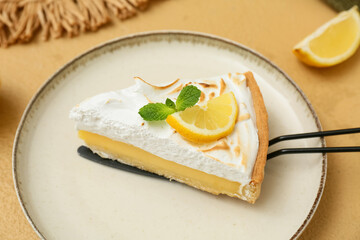 Plate with piece of tasty lemon pie on beige grunge background, closeup