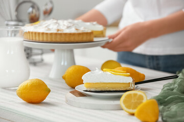 Piece of tasty lemon pie on table in light kitchen, closeup