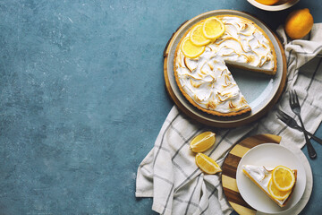 Naklejka premium Plate with tasty lemon pie and ingredients on blue grunge background