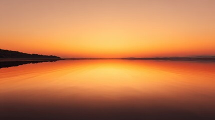 Naklejka premium Tranquil Golden Sunset Reflected on Calm Water, Silhouetted Horizon.