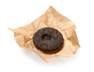 Dry pressed puer tea with wrapping paper on white background