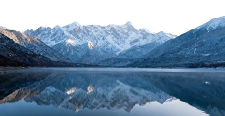 Snow-capped mountains reflected in a calm lake at dawn