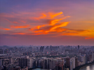 Obraz premium Dramatic Cityscape Panorama with Stunning Orange Sky and Purple Clouds at Dusk
