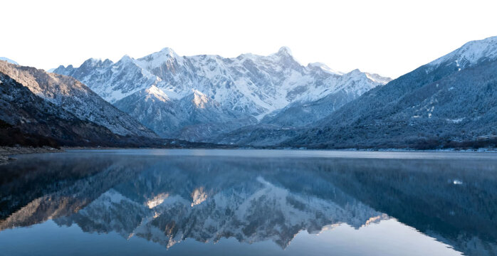 Snow-capped mountains reflected in a calm lake at dawn