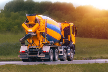 Fototapeta premium Concrete mixer lorry moving through green nature