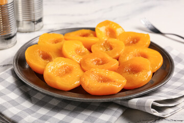Plate with sweet canned peaches on white background, closeup