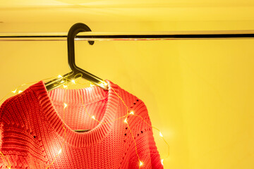 Cozy red sweater with decorative fairy lights, perfect for Christmas clothing sales, holiday fashion campaigns, winter promotions, and seasonal retail marketing.