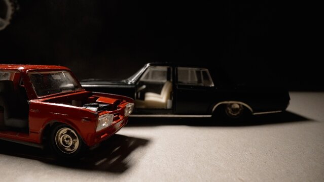 Repairing red diecast model car under spotlight