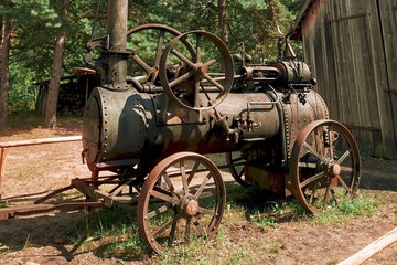 Fototapeta premium Historic steam-powered farming equipment on grass