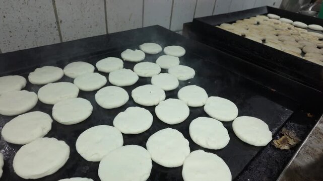 Hot arepas cooking on a grill, delicious and inviting scene