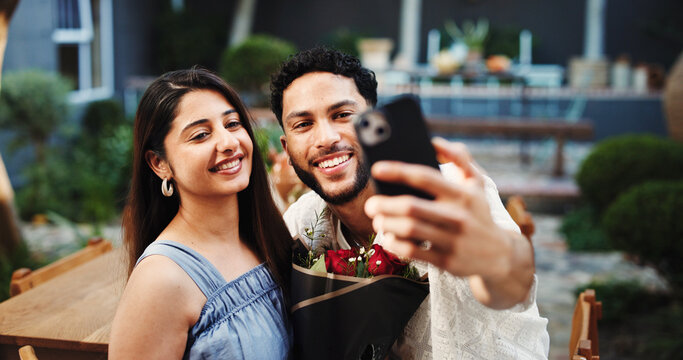 Happy, couple and selfie with roses, restaurant and excited for anniversary celebration and bonding. Outdoor, man and picture with woman on date, online and post for valentines day, romance or event - Powered by Adobe