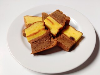 slice of chocolate vanilla marble cake with raisins. close-up of marble cake slices on white plate.