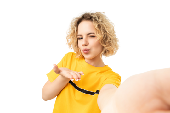Girl in yellow shirt blows a kiss selfie, isolated on white, PNG