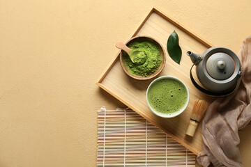 Fototapeta premium Composition with wooden tray, bowl of tasty matcha tea and teapot on beige grunge background