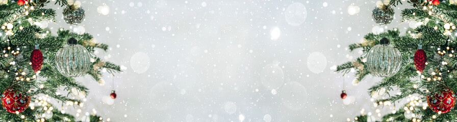 Christmas tree with red decorations on light background with bokeh, sparking, glowing. Merry...