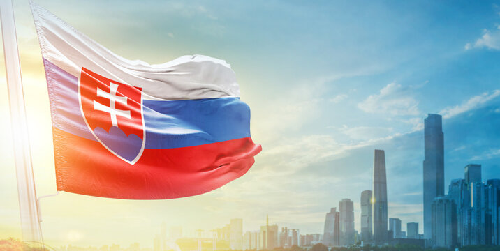 Slovakia flag wavering in beautiful clouds with building skyline. The flag with drone shot in beautiful sky. Slovakia national flag for independence day.