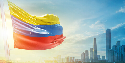 Venezuela flag wavering in beautiful clouds with building skyline. The flag with drone shot in beautiful sky. Venezuela national flag for independence day.