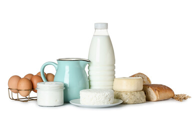 Different dairy products with eggs, bread and wheat spikelets on white background