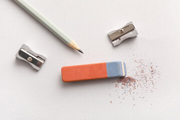 Eraser with sharpeners and pencil on white background