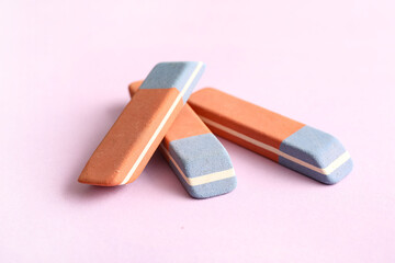 School erasers on lilac background