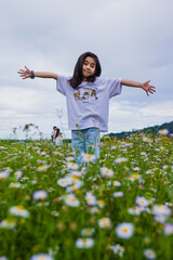 Girl Spreading Arms in Daisy Field