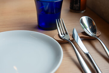 木のテーブルに並べられた皿とカトラリーのテーブルセット
