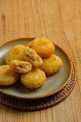 Combro on plate. Combro , traditional food made from grated cassava which is shaped round or oval and filled with oncom or tempeh , chili sauce then fried. Fried mashed cassava filled