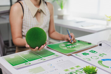 Person doing esg reporting holding green moss sphere