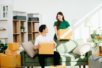 Capture the essence of moving day with a smiling couple unpacking boxes in a bright, cozy living room.