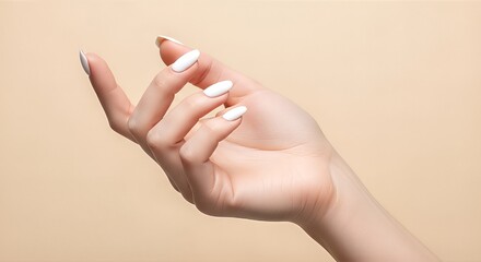 Elegant hand with manicured nails against neutral backdrop.