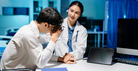 Obraz premium Asian doctor comforting stressed patient in hospital office, offering emotional support and professional mental health consultation with empathy and care.