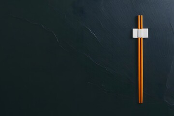 Traditional wooden chopsticks with a simple white holder, positioned vertically on a dark, textured background, ready for dining