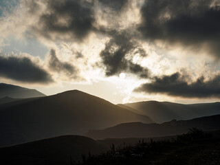 Sunlit Mountain Peaks under a Cloudy Sky Landscape