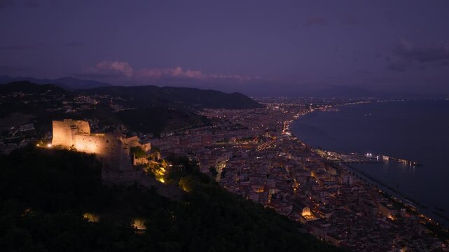 Mountaintop Medieval Fortress Of Arechi Castle At Night Overlooking The City Of Salerno In Italy. Aerial Drone Shot