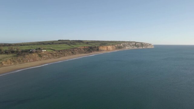Aerial view of Sandown a seaside resort and civil parish on the south-east coast of the Isle of Wight, England. Drone moving forward over the sea in direction to the white cliffs. 4K