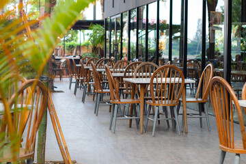 Outdoor dining area with modern tables and chairs under warm evening lights, creating a cozy and inviting café atmosphere.
