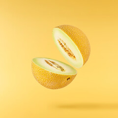 Fresh ripe Galia Melon falling in the air isolated on yellow background