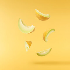 Fresh ripe Galia Melon falling in the air isolated on yellow background